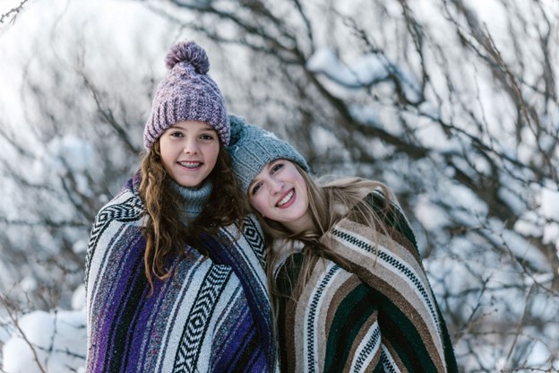 Two girls wrapped in blankets smile after receiving general dentistry in Las Vegas, NV