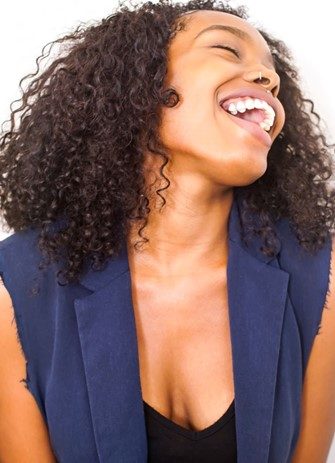 Black woman smiles widely after teeth whitening in Las Vegas, NV