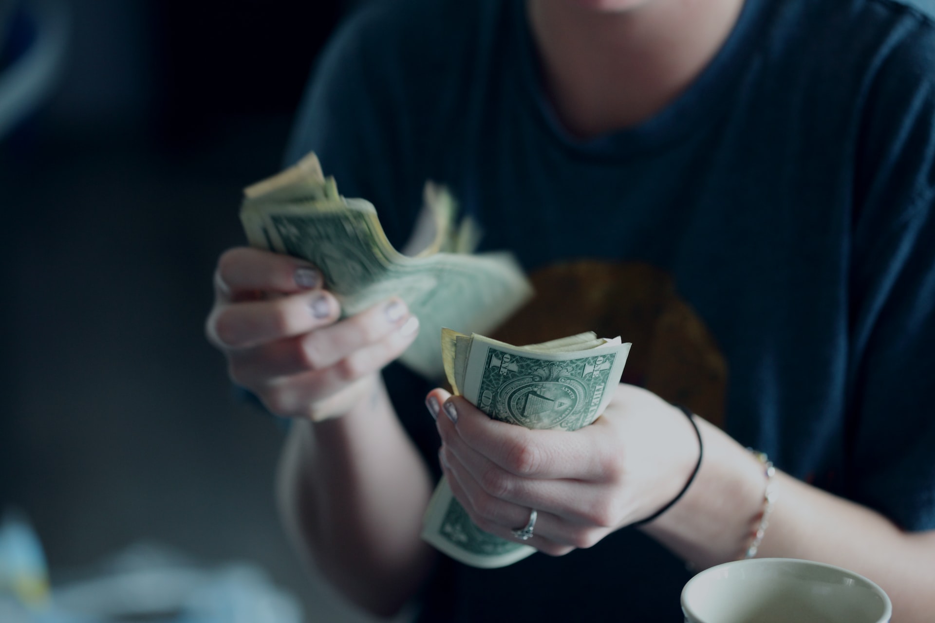 A close-up image of hands counting dollar bills to convey the effort of finding an affordable dentist in Las Vegas, NV