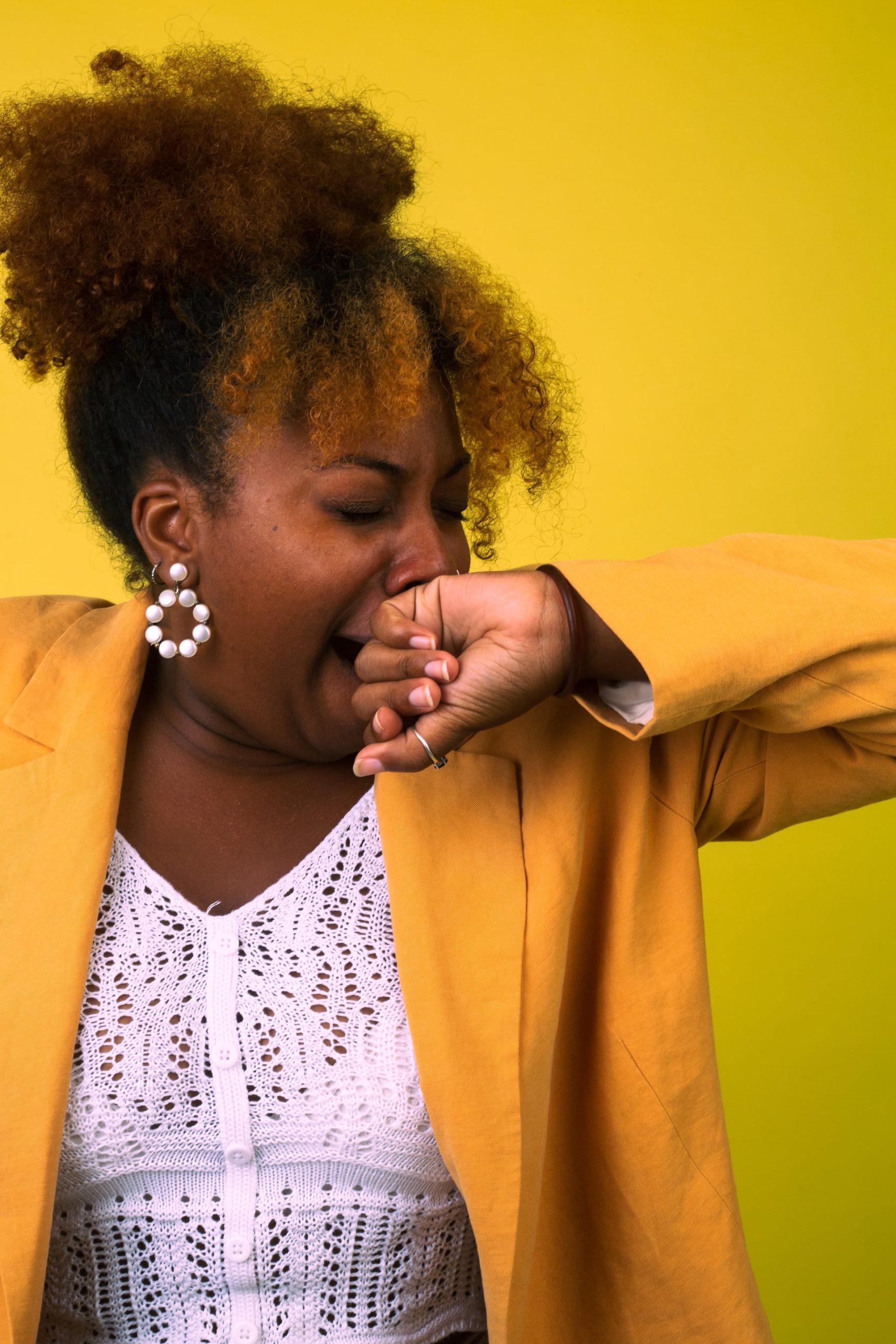 Woman covers her yawn with her hand after pursuing sleep apnea treatment at a general dentistry center in Las Vegas, NV