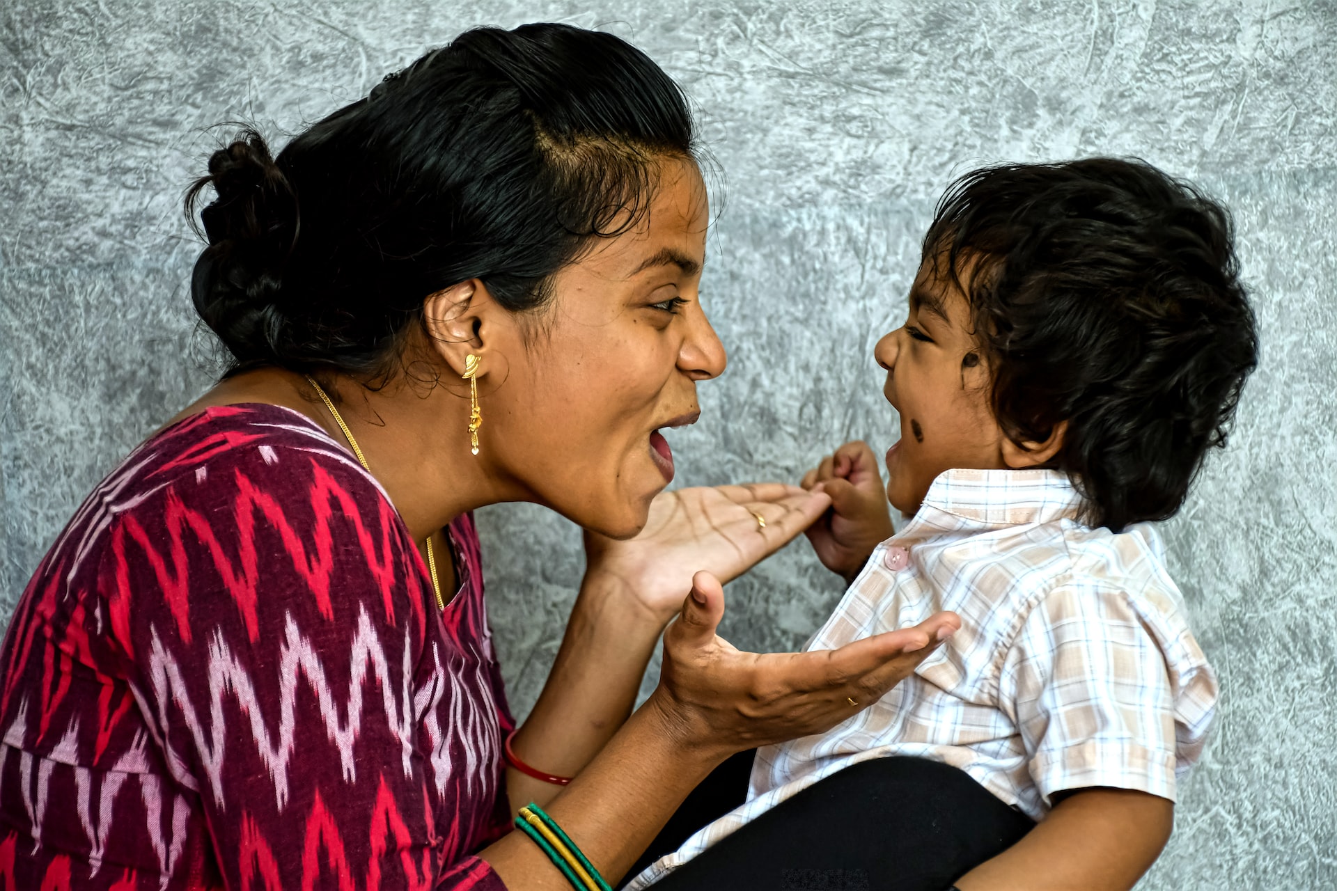 Indian mother and toddler son looking at each other and smiling