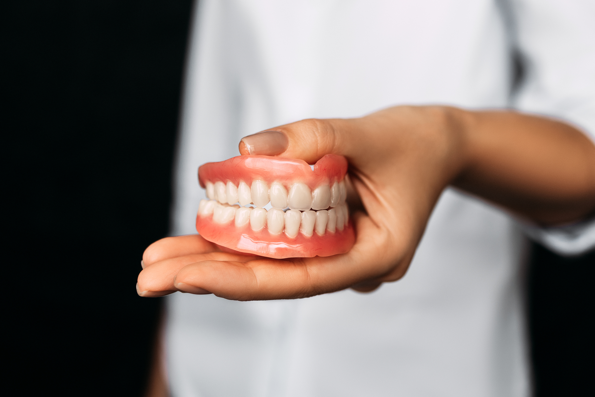 dentist holding full dentures