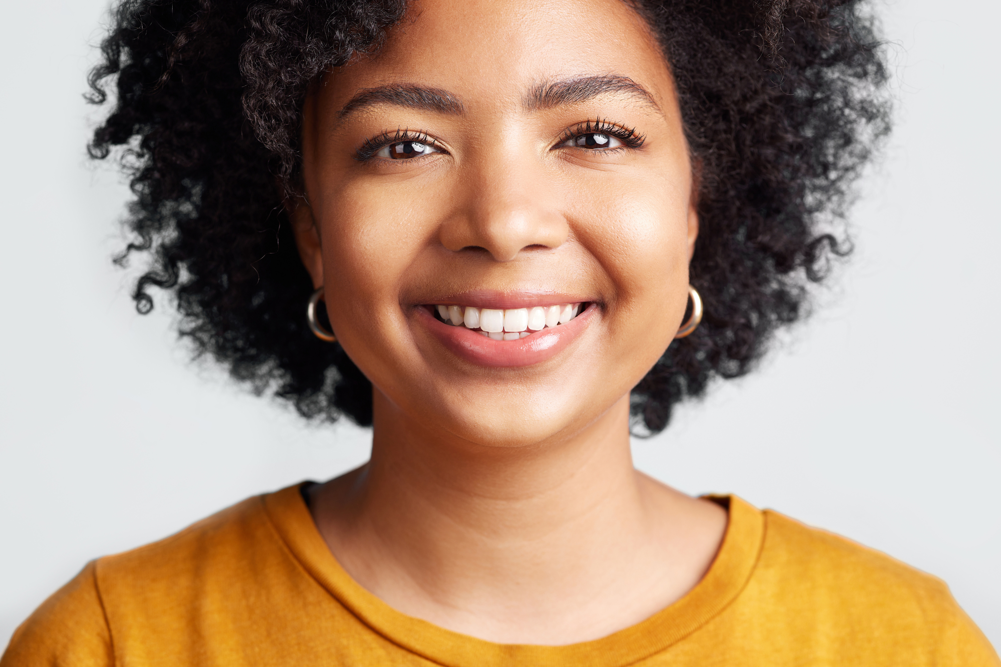 black woman smiling in yellow shirt