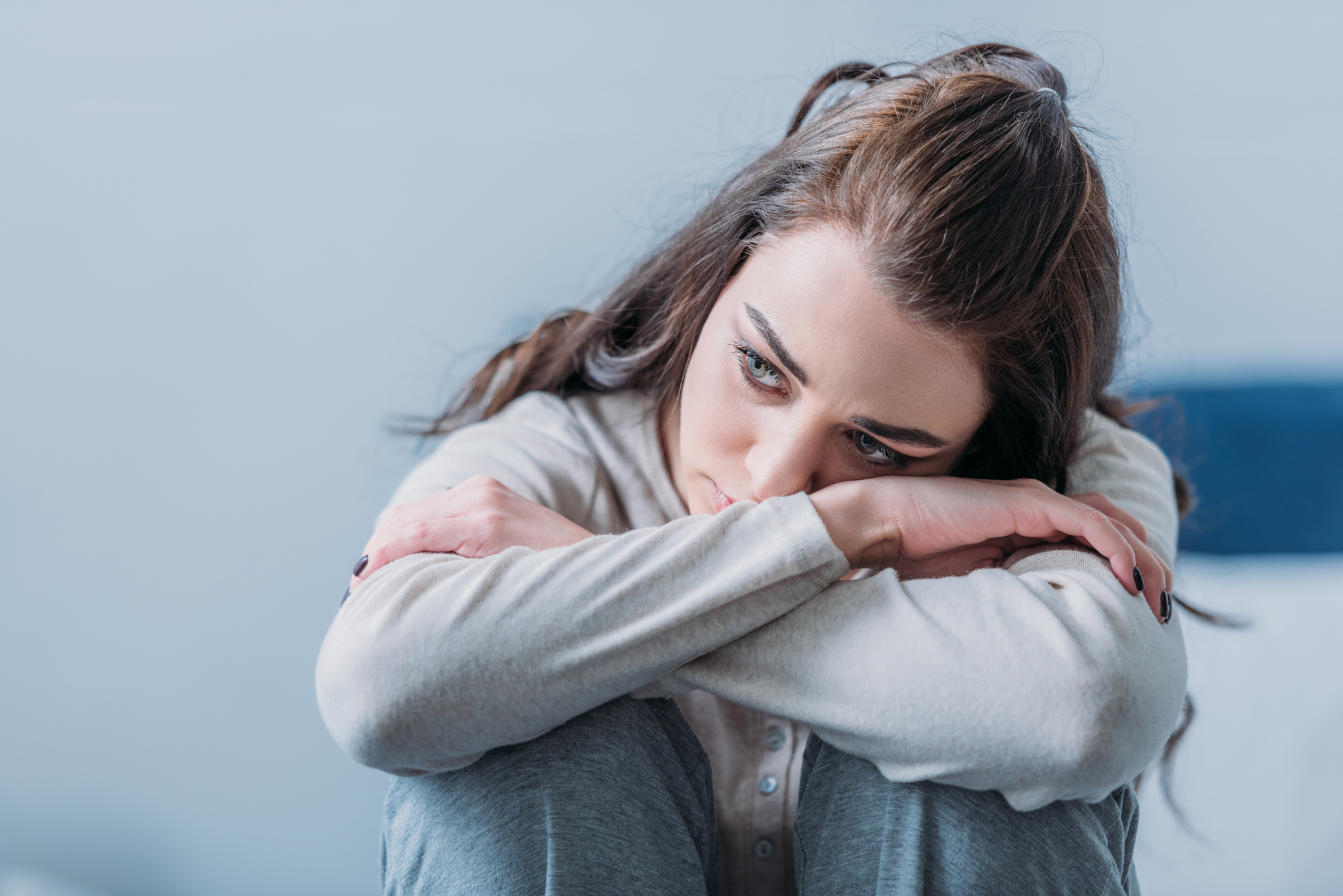 woman putting her head on her knees suffering from fear of going to the dentist
