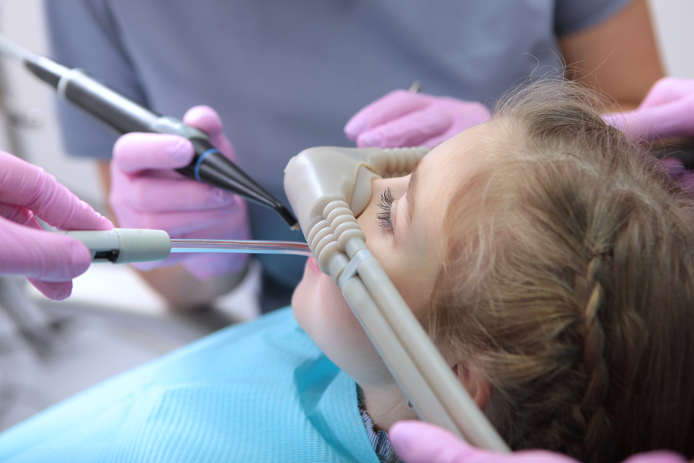Dental care for children. Superficial sedation. Treatment of children's teeth with nitrous oxide. Photos in the interior of the clinic. Side view.