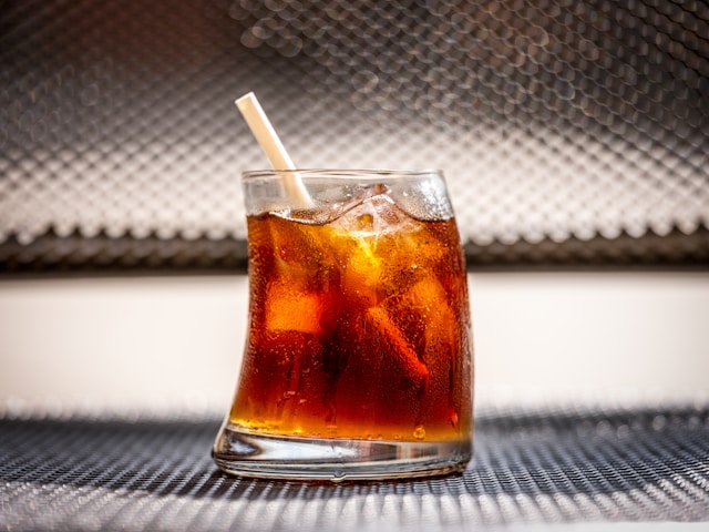 small soda in a glass with a straw